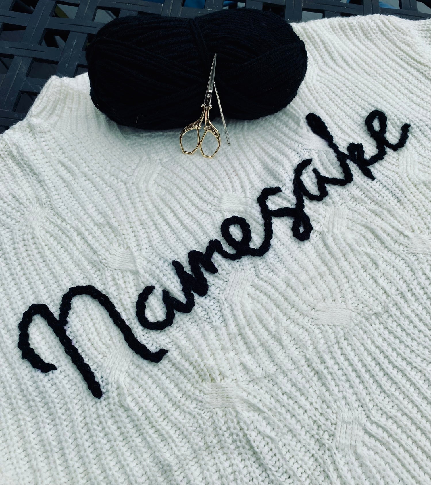 White Namesake sweater embroidered with black yarn